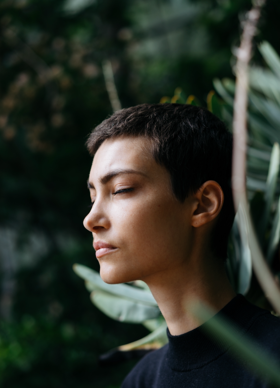 women with pixie hair cut meditating in nature