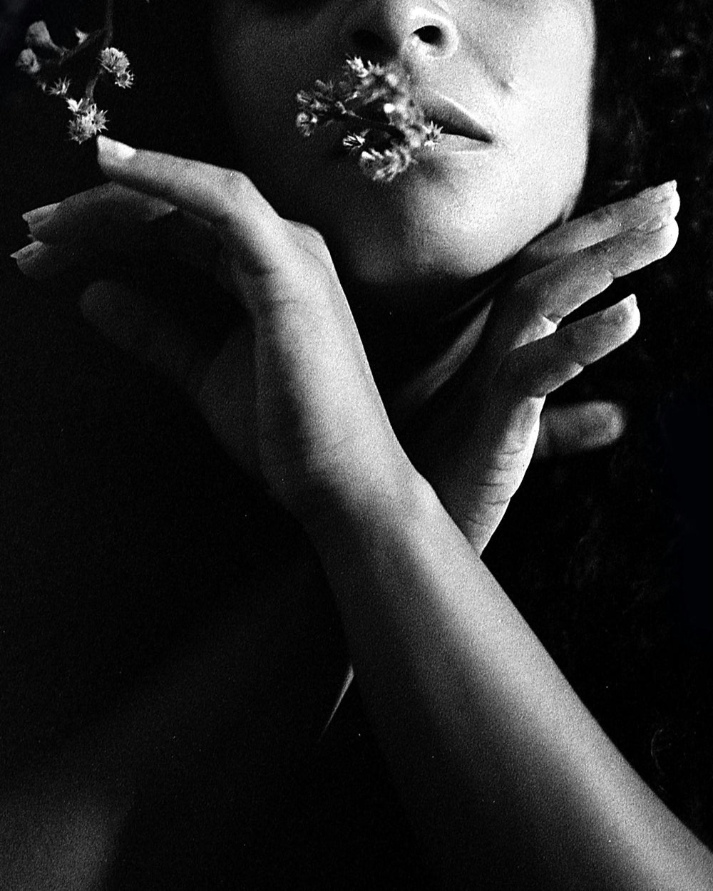 black and white photo of women with herbs in her mouth