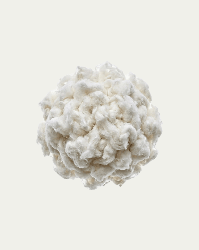 Clump of white cotton on a light beige background