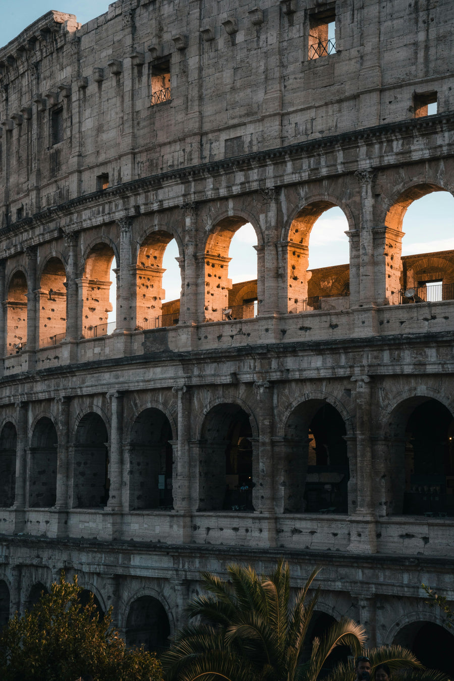 Close-up of the Colosseum in Rome with sunlight streaming through the arches.