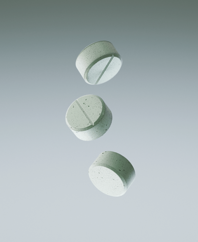 Three green mints falling against a gray background