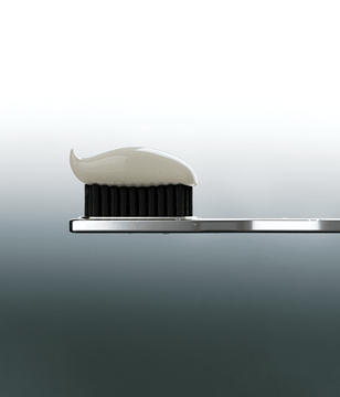 Metallic toothbrush a small amount of toothpaste on a gray background