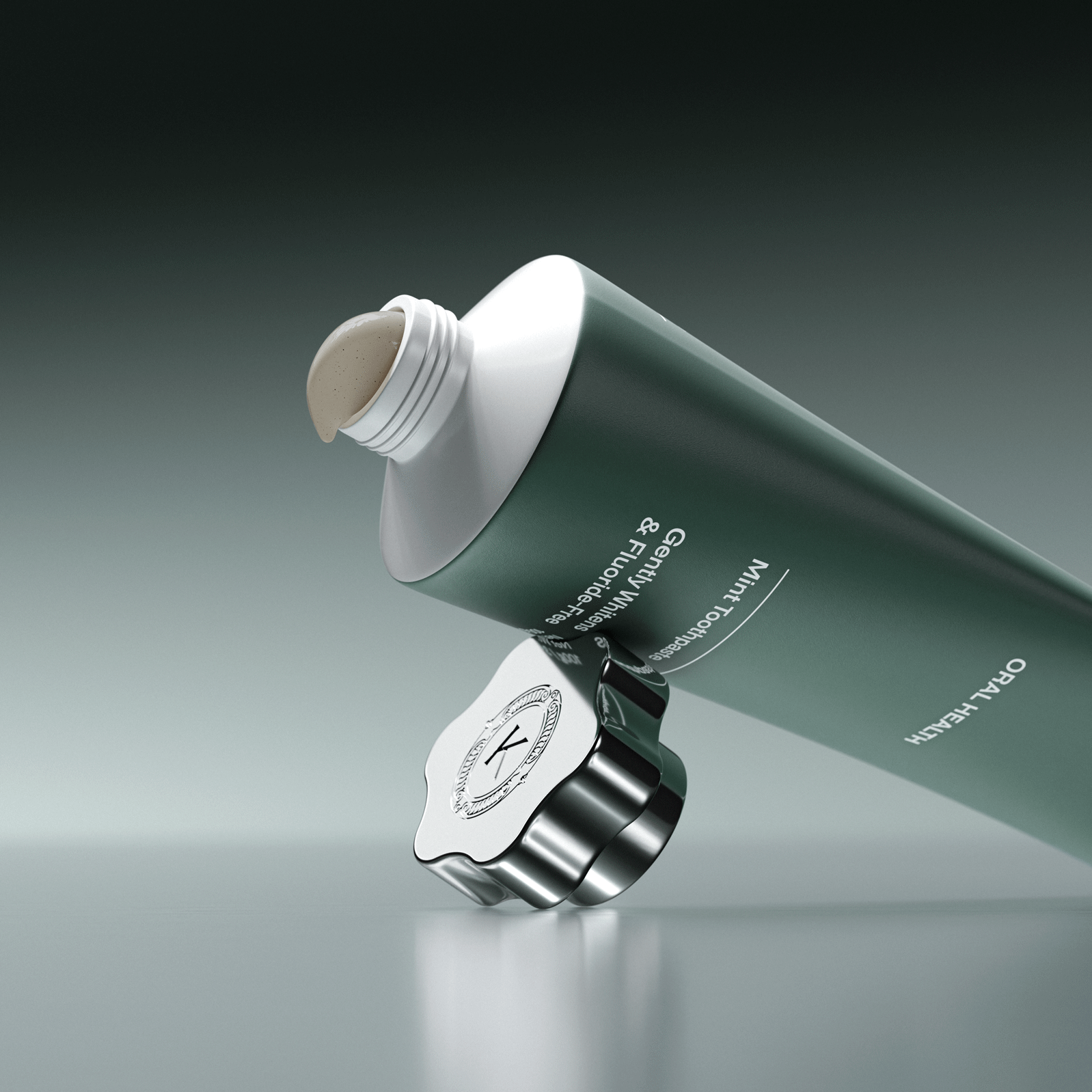 Green and white toothpaste tube with a silver cap on a gray background